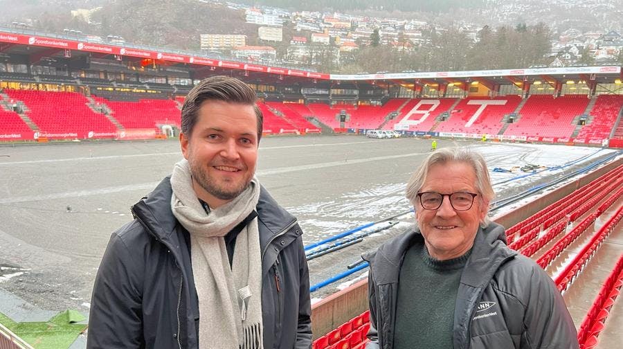 To menn som står for et fotballstadion der det skal legges nytt gress.